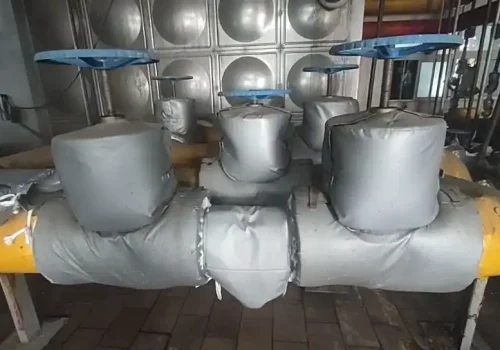 Valve insulation and soundproofing cover installed on industrial pipeline for thermal and noise reduction
